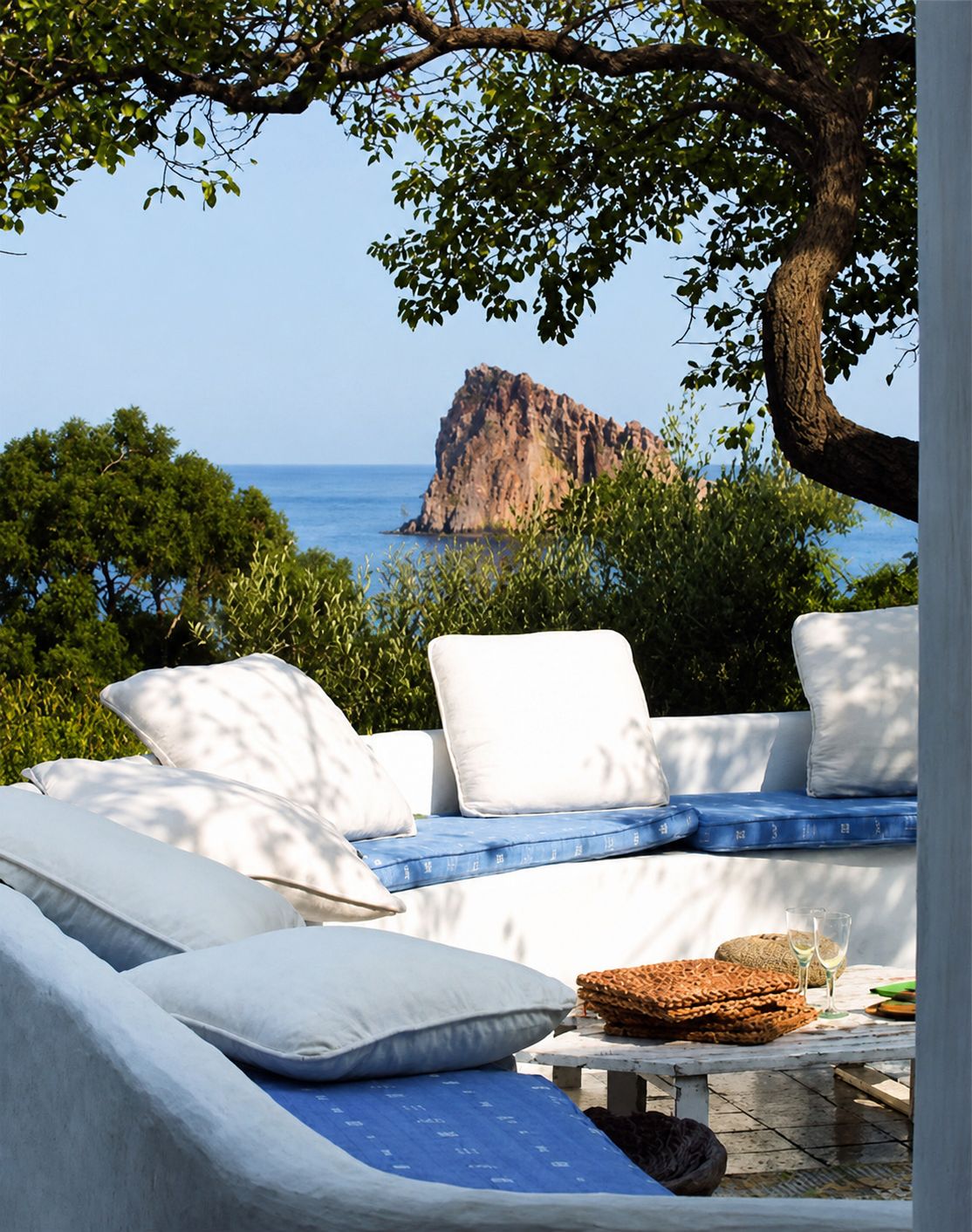 Terrazza vista mare con divani bianchi e cuscini blu